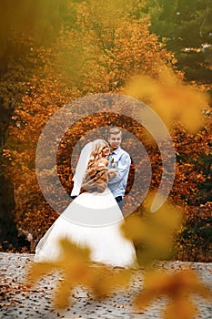Beautiful young wedding couple stand happy together in a park in