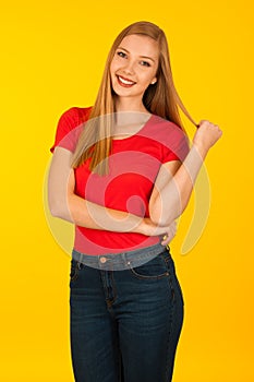 Beautiful young woma in red t shirt and jeans over yellow background