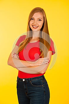 Beautiful young woma in red t shirt and jeans over yellow background