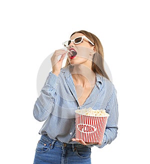 Beautiful young woman with 3D cinema glasses eating popcorn on white background