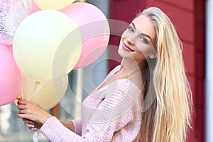 Beautiful young woman with air balloons outdoors