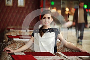 Beautiful young woman alone waiting at a table in restaurant