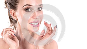 Beautiful young woman applying cosmetic cream treatment on her face on white background. Skin care concept