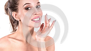 Beautiful young woman applying cosmetic cream treatment on her face on white background. Skin care concept