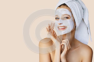 Beautiful young woman applying facial mask on her face. Skin care and treatment, spa, natural beauty and cosmetology concept