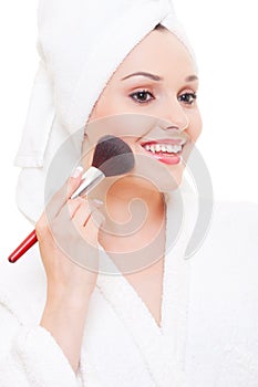 Beautiful young woman applying make-up