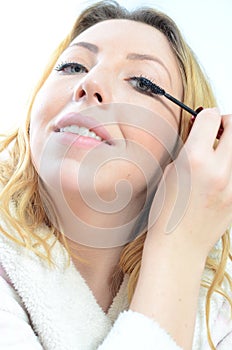 Beautiful young woman applying makeup