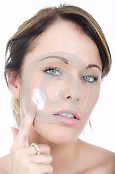 Beautiful Young Woman Applying Moisturizing Cream to her Face