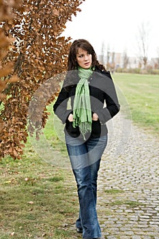 Beautiful young woman in autumn goes for a walk