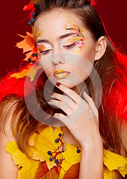 Beautiful young woman with autumn make up posing in studio over