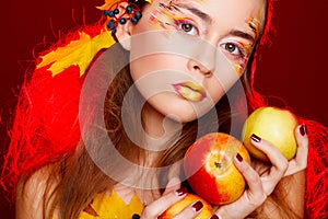 Beautiful young woman with autumn make up posing in studio over