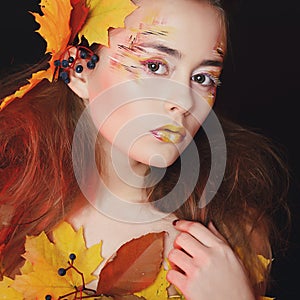 Beautiful young woman with autumn make up posing in studio over