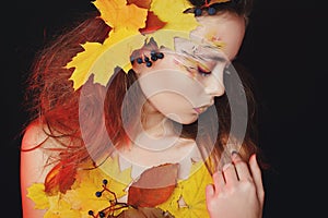 Beautiful young woman with autumn make up posing in studio over