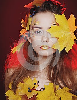 Beautiful young woman with autumn make up posing in studio over