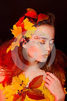 Beautiful young woman with autumn make up posing in studio over