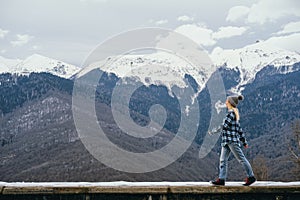 Beautiful young woman on background of snowy mountains