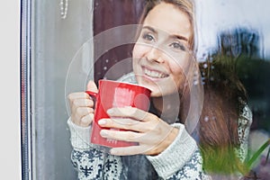 Beautiful young woman on a balcony enjoing morning with cup of coffee photo
