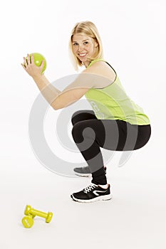 Beautiful young woman with a ball and dumbbells doing exercises