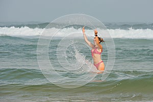 beautiful young woman bathing in the ocean in bikini