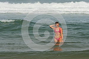 beautiful young woman bathing in the ocean in bikini