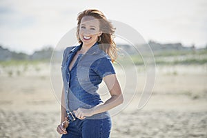 Beautiful young woman at beach - denim romper photo
