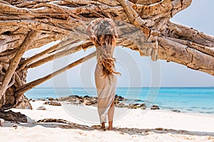 Beautiful young woman on the beach at hot summer day