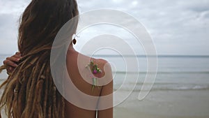 Beautiful young woman on the beach. Over the shoulder medium close up shot
