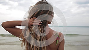 Beautiful young woman on the beach. Over the shoulder medium close up shot