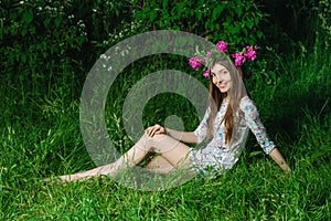 Beautiful young woman with beautiful legs in green spring grass