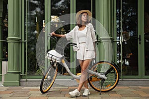 Beautiful young woman bicycle near modern building outdoors