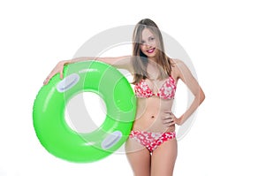 Beautiful young woman in bikini posing with a big green rubber ring