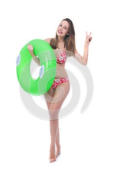 Beautiful young woman in bikini posing with a big green rubber ring