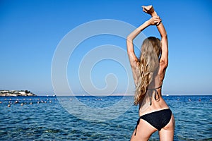 Beautiful young woman in bikini on the sunny beach