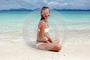 Beautiful young woman in bikini on the sunny tropical beach