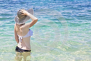 Beautiful young woman in bikini on the sunny tropical beach