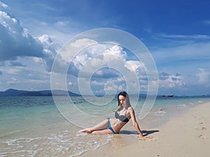 Beautiful young woman in bikini on the tropical sunny beach