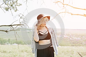 Beautiful young woman in black against a landscape of sky and field