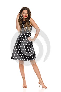 Beautiful Young Woman In Black Cocktail Dress In Polka Dots And Beige High Heels Sandals