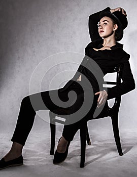 Beautiful young woman in a black hat and a black jacket