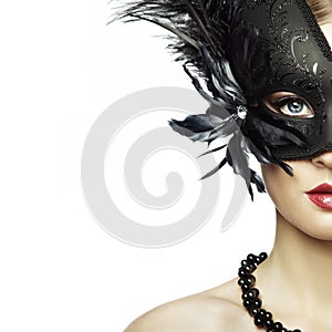 Beautiful young woman in black mysterious venetian mask