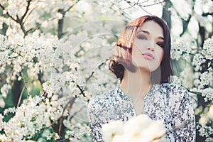 Beautiful young woman in blooming sakura