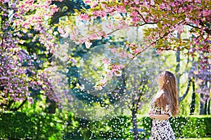 Beautiful young woman in blooming spring park