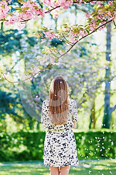 Beautiful young woman in blooming spring park