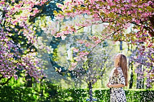 Beautiful young woman in blooming spring park