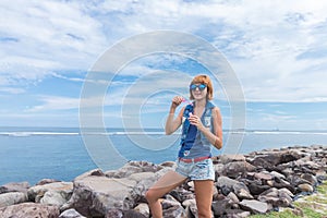 Beautiful young woman blowing bubble in outdoor, nature, near the ocean. Tropical magic island Bali, Indonesia.