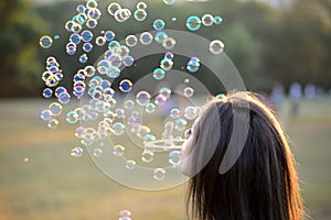 Beautiful Young Woman Blowing Bubbles Outside