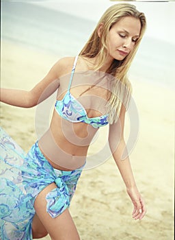 Beautiful young woman in blue swimsuit with pareo