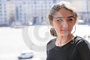 Beautiful young woman on blurred street background photo