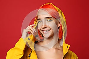 Beautiful young woman with bright dyed hair on red background
