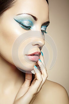 Beautiful young woman with bright make-up and manicure